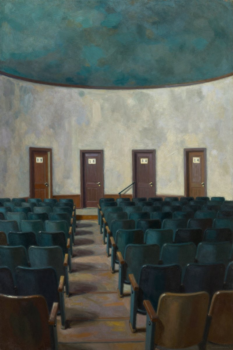 The auditorium of the building is a stark keystone shape, with rows of unbroken seats curving from side to side in dim darkness.